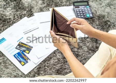 Young woman unemployed Looks into her Empty Wallet are stressed about payment loan problem. A personal financial crisis concept. Debt, loan concept.Recession Situation and Hopelessness Crisis Concept. Royalty-Free Stock Photo #2202262997