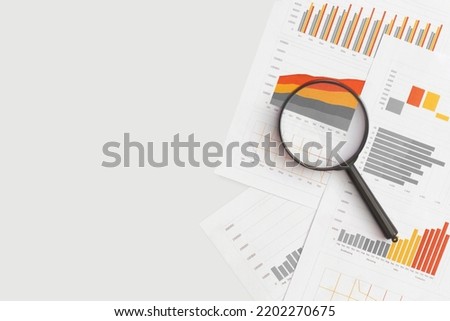 Business graphs, charts and magnifying glass on table. Financial development, Banking Account, Statistics Royalty-Free Stock Photo #2202270675