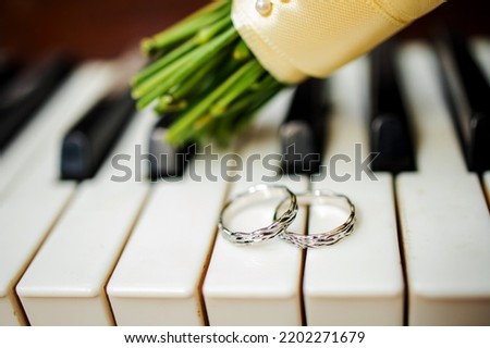 Wedding rings and a bouquet on a piano. Wedding symbols, attributes. holiday.
