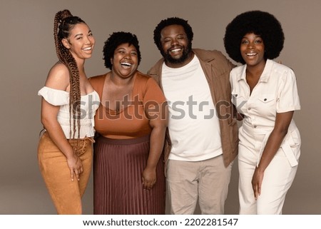 Three quarter length shot of a group of gorgeous multiracial people laughing together on a neutral background. Royalty-Free Stock Photo #2202281547