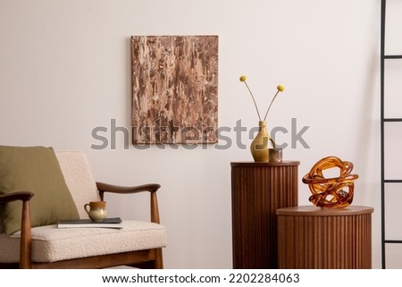 Retro and bright space of living room with mock up poster frame, wooden side table, beige armchair ,green pillow and elegant personal accessories. Beige wall. Minimalist home decor. Template.	