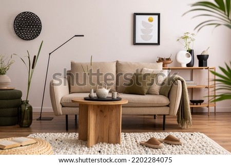 Domestic and cozy interior of living room with beige sofa, plants, shelf, coffee table, boucle rug, mock up poster frame, side table, plant and elegant decoration Beige wall. Home decor. Template.
