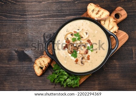 Mushroom champignon soup with bread and fresh mushrooms. top view , autumn seasonal cream soup with vegetables  Royalty-Free Stock Photo #2202294369