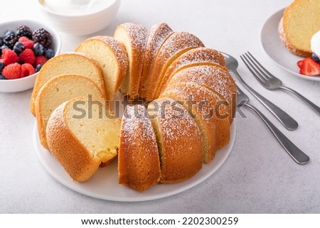 Pound cake baked in a bundt pan, traditional vanilla or sour cream flavor, dusted with powdered sugar Royalty-Free Stock Photo #2202300259