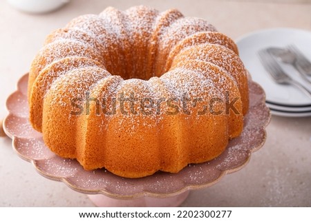Pound cake baked in a bundt pan, traditional vanilla or sour cream flavor, dusted with powdered sugar Royalty-Free Stock Photo #2202300277
