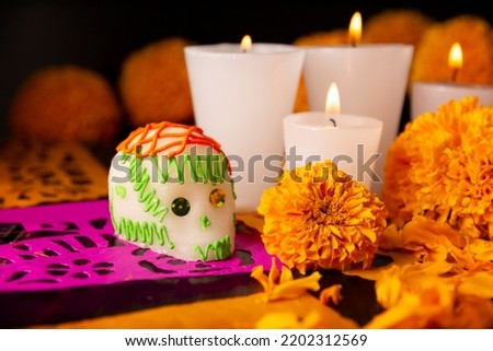 Sugar skulls with Candle, Cempasuchil flowers or Marigold and Papel Picado. Decoration traditionally used in altars for the celebration of the day of the dead in Mexico Royalty-Free Stock Photo #2202312569