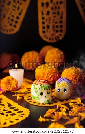 Sugar skulls with Candle, Cempasuchil flowers or Marigold and Papel Picado. Decoration traditionally used in altars for the celebration of the day of the dead in Mexico Royalty-Free Stock Photo #2202312577