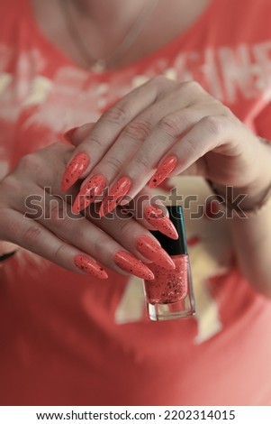 Female hands with long nails and neon orange nail polish