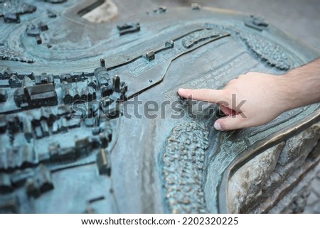 Hand points on city map with braille letters blind alphabet braille