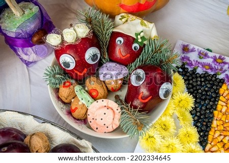 Decorative composition of apples, nuts and flowers for autumn festival display, food friendly