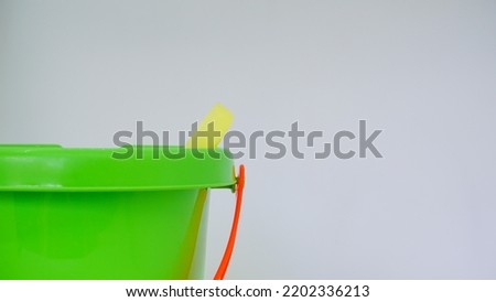 Kids green bucket and red spade summer holiday concept isolated against white background
