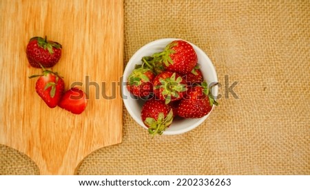 Fresh strawberries in glass bowl flat lay on cutting board. Healthy food on burlap mock up. Delicious, sweet, juicy and ripe berry background with copy space for text