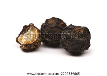 Half and whole peppercorns isolated on a white background. Macro photography of black pepper with full depth of field