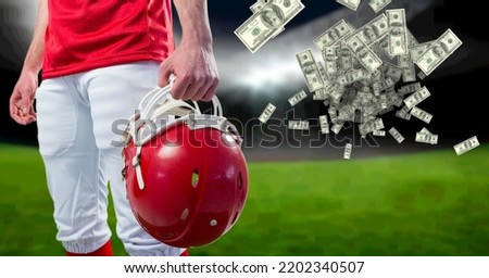 Composition of american dollar banknotes over midsection of american football player. business, sport and competition concept digitally generated image.