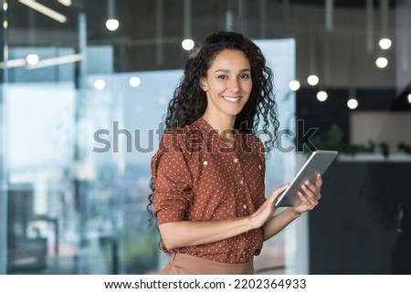 Young and successful female programmer, portrait of female engineer with tablet computer startup worker working inside office building using tablet for testing applications smiling looking at camera Royalty-Free Stock Photo #2202364933