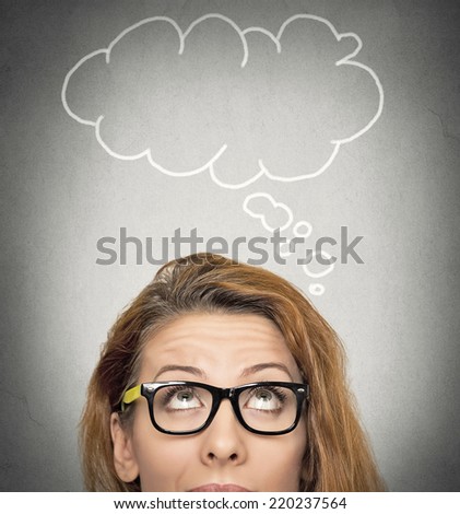 Headshot beautiful woman with thoughtful expression and blank bubble with copy space above her head, looking up isolated grey wall background. Human face expressions, emotions, feelings, body language