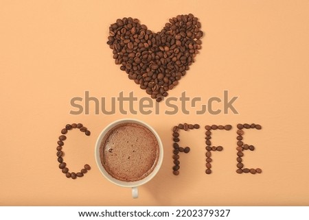 Heart shaped roasted coffee beans and text i love coffee on beige background,top view,flat lay,minimal creative concept,advertising for modern coffee shop,cafe,bar,selective focus