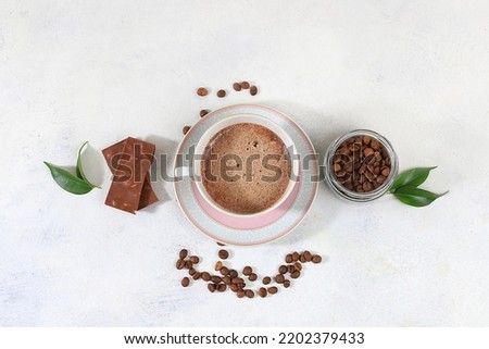 Coffee drink with milk, chocolate and whipped cream, cappuccino coffee, latte, cinnamon, coffee beans on a gray concrete table, modern coffee shop advertisement, selective focus