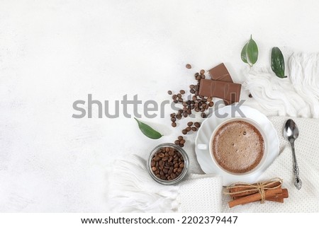 Cozy home table with cappuccino coffee,coffee beans cinnamon,chocolate,healthy breakfast with ingredients, hello autumn concept, hygge style, modern coffee shop advertisement, selective focus, 