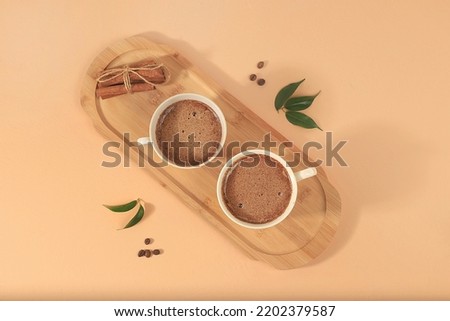 Coffee drink with milk, chocolate and whipped cream, cappuccino coffee, latte, cinnamon, coffee beans on a light table, modern coffee shop advertisement, minimal creative composition, selective focus