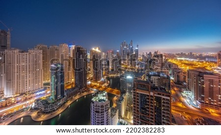 Panorama of various skyscrapers in tallest recidential block in Dubai Marina aerial night to day transition timelapse with artificial canal. Many towers in JBR district and yachts before sunrise