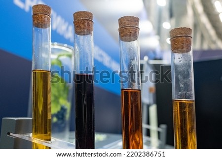 Four glass test tubes with multi-colored liquid inside in the laboratory