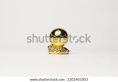 A picture of miniature golden ball trophy on white background