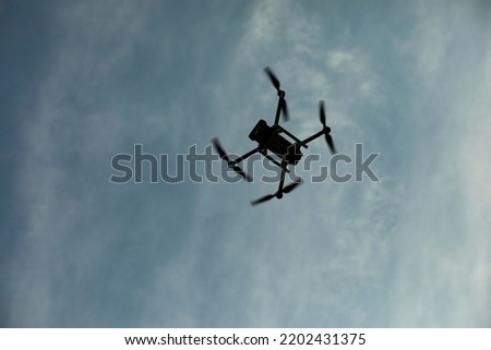 Drone in sky. Quadro copter flies in air. Surveillance from height. Four propellers. Flight Technology. Royalty-Free Stock Photo #2202431375