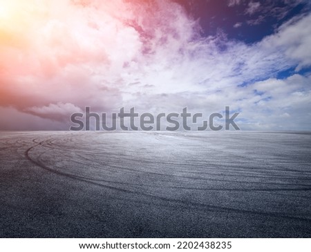 Empty asphalt race track road with beautiful sky clouds at sunset