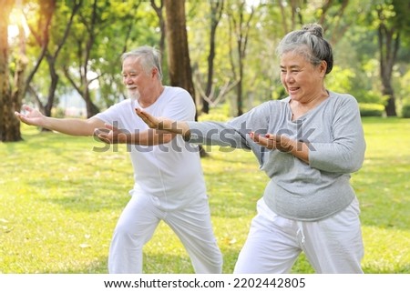 Asian senior couple practice yoga excercise, tai chi tranining, stretching and meditation together with relaxation for healthy in park outdoor after retirement. Happy elderly outdoor lifestyle concept Royalty-Free Stock Photo #2202442805