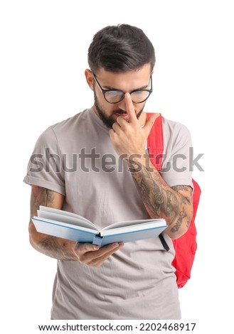 Handsome tattooed student with book isolated on white
