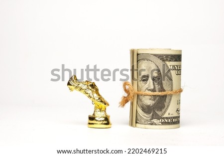 A picture of miniature golden shoe with fake money on copyspace white background.