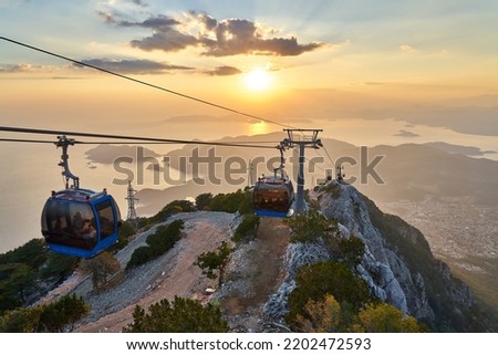 Amazing sunset time at Babadag. Teleferik cable cars are used to reach to peak of mountain. Fethiye, Mugla, Turkey.  Royalty-Free Stock Photo #2202472593