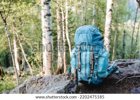 A tourist backpack stands on the ground, a blue bag for things, sports equipment, a hike in the mountains, a bowl for transportation. High quality photo