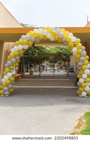 Arch from white yellow and green balloons at entrance