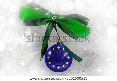 New Year's glass ball with the flag of European Union against a colorful Christmas background