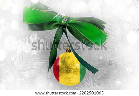 New Year's glass ball with the flag of Guinea against a colorful Christmas background