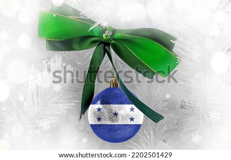 New Year's glass ball with the flag of Honduras against a colorful Christmas background