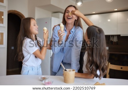 Eating ice-cream. Happy Asian family eating ice-cream at home. Beautiful child feeding mother. Royalty-Free Stock Photo #2202510769
