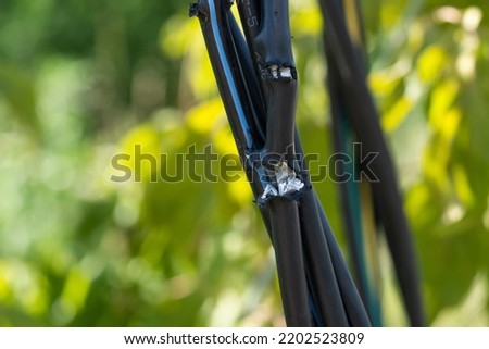 Broken black ground electric cord. Dangerous damage power electrical cable that can make electric leak and shock. Unsafe work concept Royalty-Free Stock Photo #2202523809