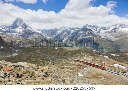 red train on the background of the Matterhorn mountain in the Swiss Alps