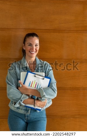 Casual businesswoman smiling with arms folded - stock photo
