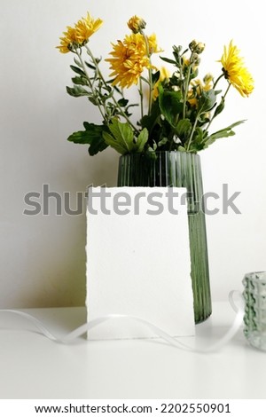 Mockup in jpeg format standing near a vase of flowers