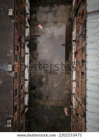 Old generic derelict industrial buildings in a dilapidated state aerial view Royalty-Free Stock Photo #2202553475
