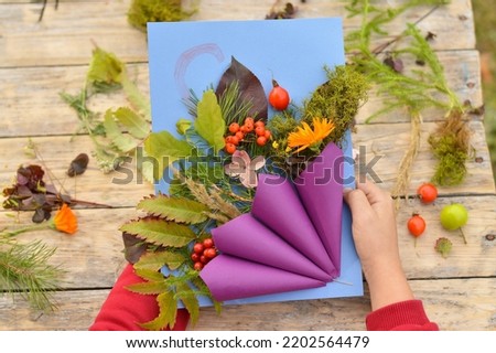 step by step instructions of Autumnal application umbrella with natural leaves. Step 8 - the finished product is in the hands of a child, can be used as a painting, a decorative element.