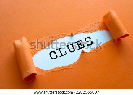 Clues on brown torn paper Royalty-Free Stock Photo #2202565007