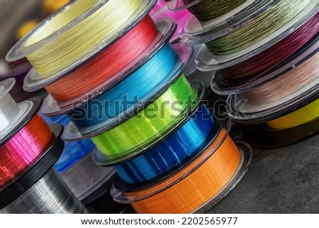 different types of fishing monofilament and braided cords in fishing reels. background Royalty-Free Stock Photo #2202565977