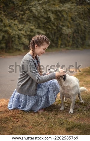 Photo of a girl with a pet dog on the street.