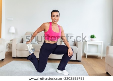 Warming Up Before Workout. Smiling Sporty Black Woman Training At Home Or Fitness Club Studio, Beautiful Female Stretching Legs After Exercises On Mat