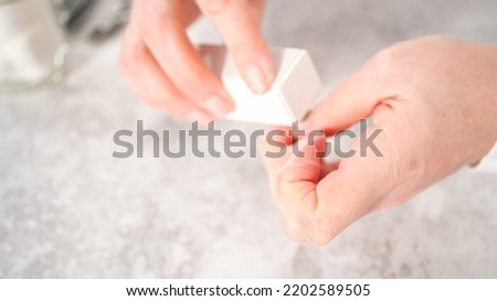 Woman finishing her manicure at home with simple manicure tools. Buffering nails with a nail buffer block. Royalty-Free Stock Photo #2202589505